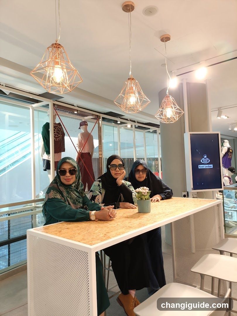 Three women at a modern bar table in a mall