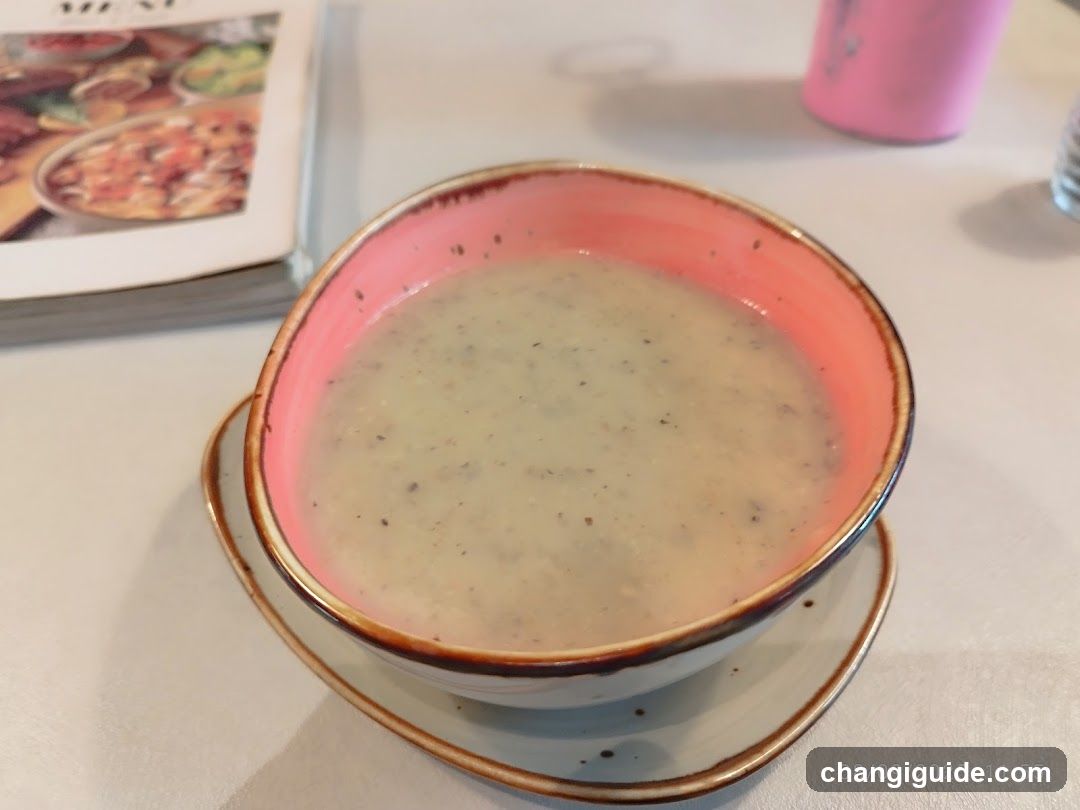 Bowl of creamy soup with pink interior bowl