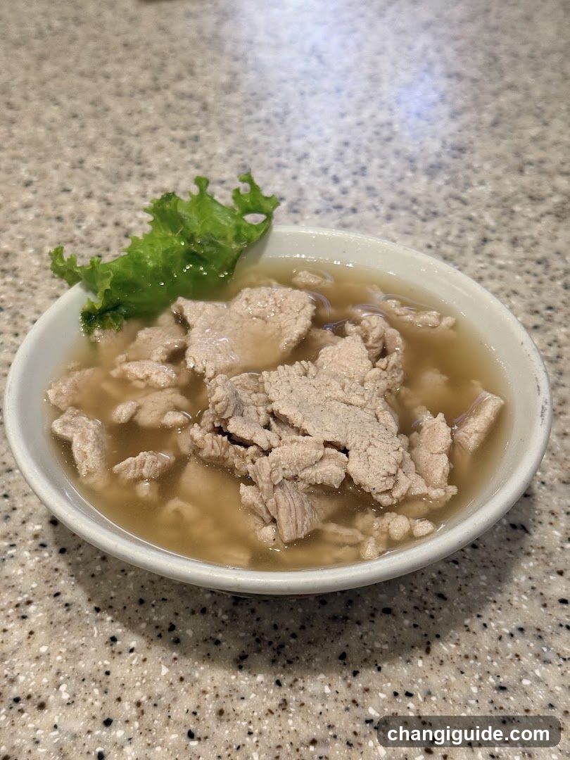 Bowl of Meat Soup with Lettuce Garnish
