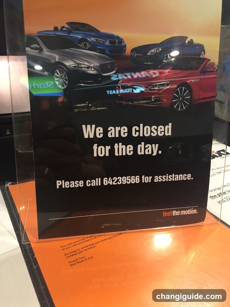 A promotional poster featuring luxury cars (Jaguar, BMW) with the message 'We are closed for the day' and a phone number for assistance. The poster is placed on an orange surface inside what appears to be a car rental shop.