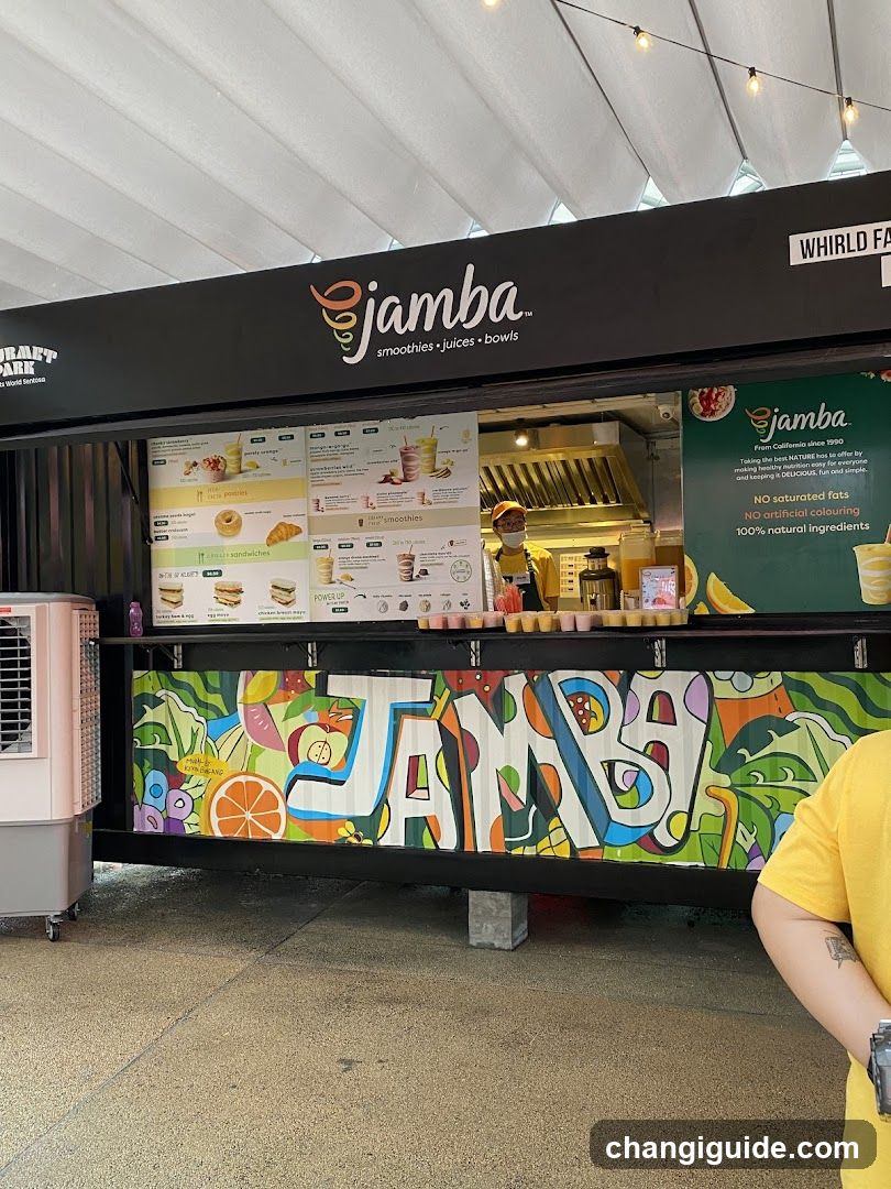 A Jamba Box food truck with a colorful mural on the side and menu boards displaying smoothies, juices, and bowls. The shop features a black exterior with visible signage and string lights above.