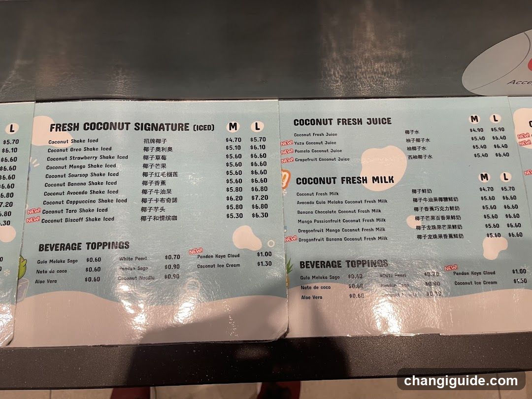 A menu board displaying coconut-themed drinks and toppings, including signature shakes, fresh juices, fresh milk, and beverage toppings.