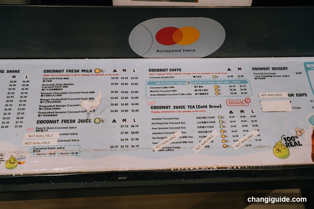 A close-up of a printed menu board featuring sections like Coconut Fresh Milk, Coconut Caffe, and Coconut Dessert with prices listed in dollars.