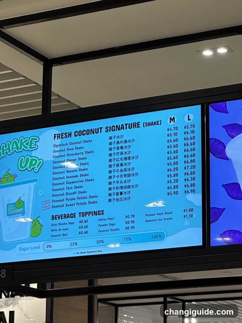 Digital menu board displaying fresh coconut signature shakes and beverage toppings with prices in M and L sizes.