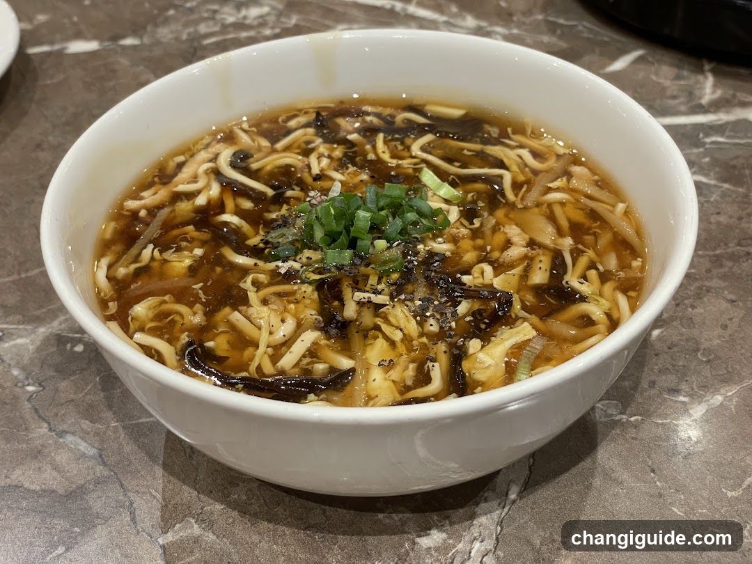 Bowl of Spicy Tofu Soup with Vermicelli and Green Onions