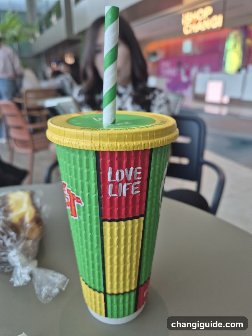 Rasta-themed drink cup with straw and food on table