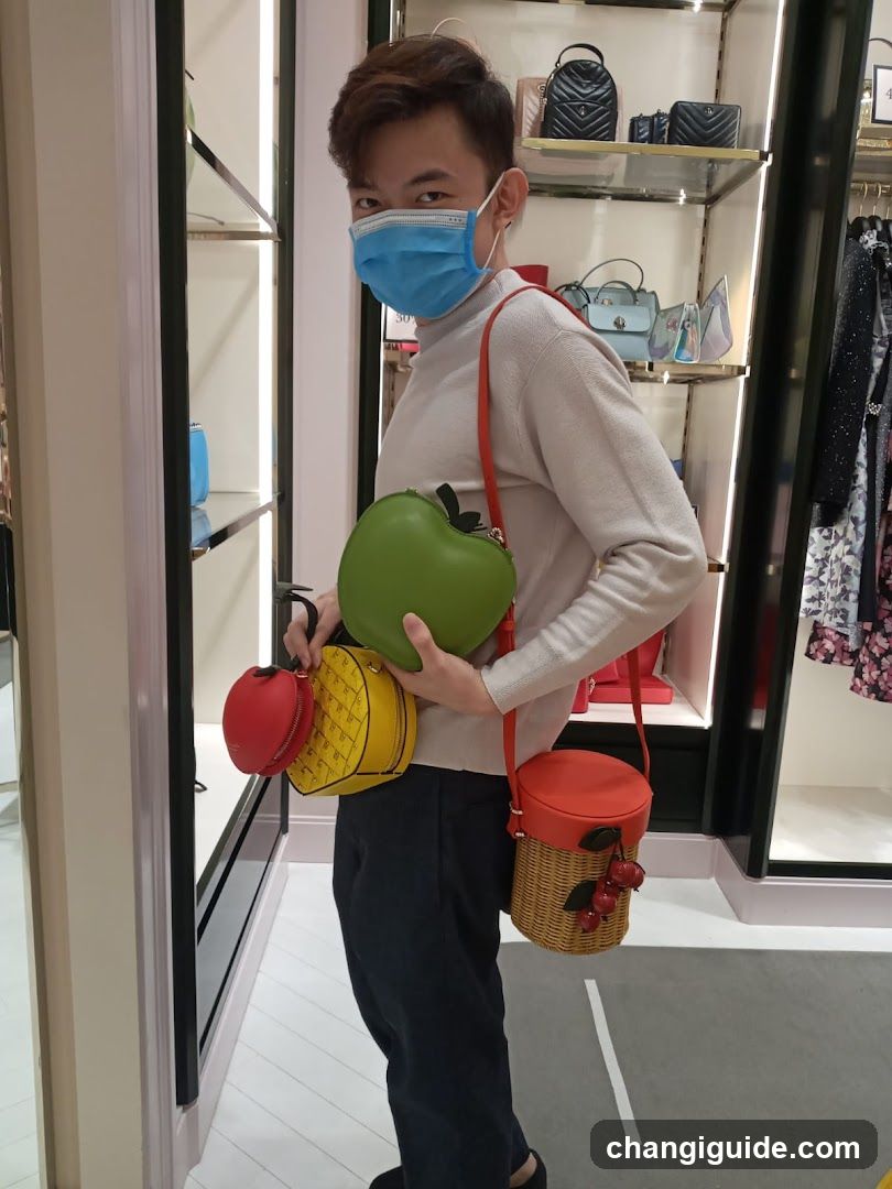 Person holding colorful fruit-shaped bags in a store