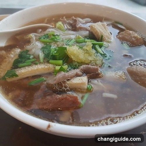 Bowl of Noodle Soup with Meat and Greens