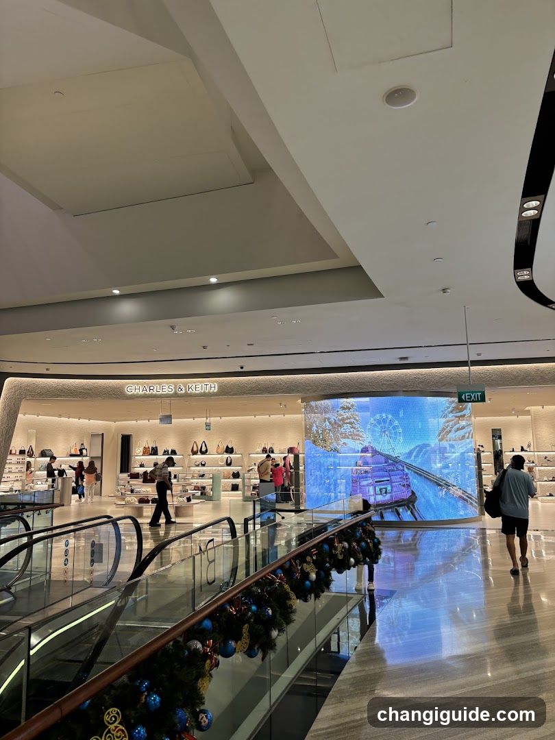 Shopping Mall Interior with Storefronts and Digital Display