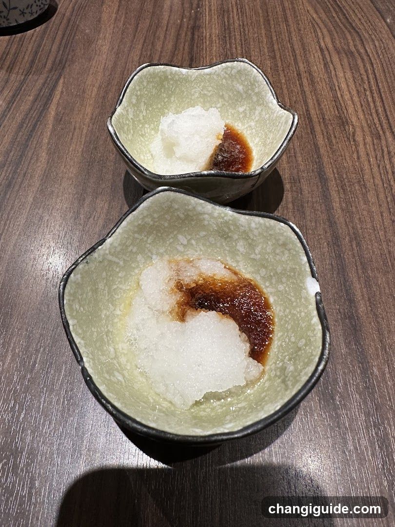 Two small ceramic bowls with condiments on a wooden table