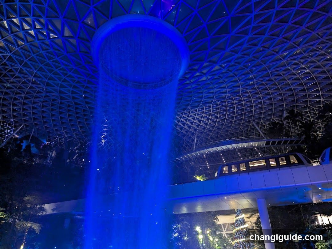Blue-lit indoor waterfall scene