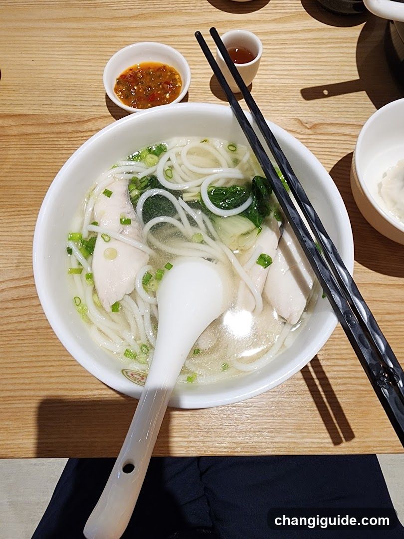 Bowl of Noodle Soup with Chopsticks and Sauce Dishes