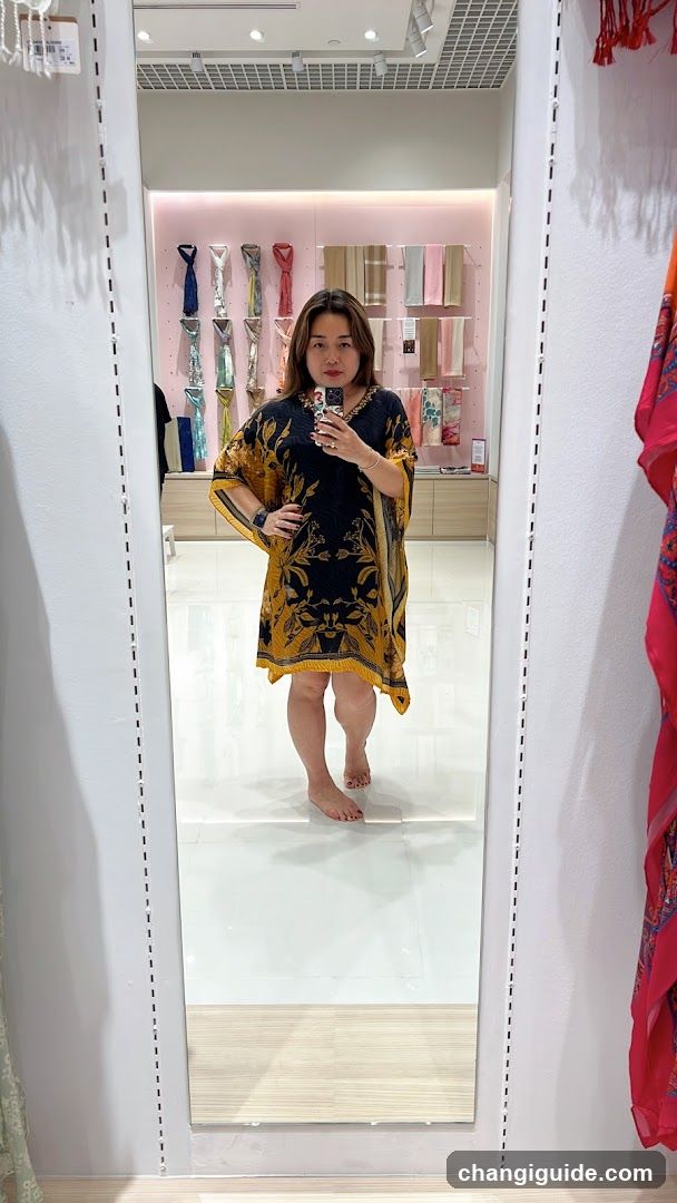 Woman trying on patterned dress in store mirror