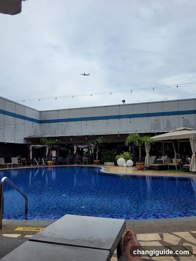Poolside View with Airplane in Sky