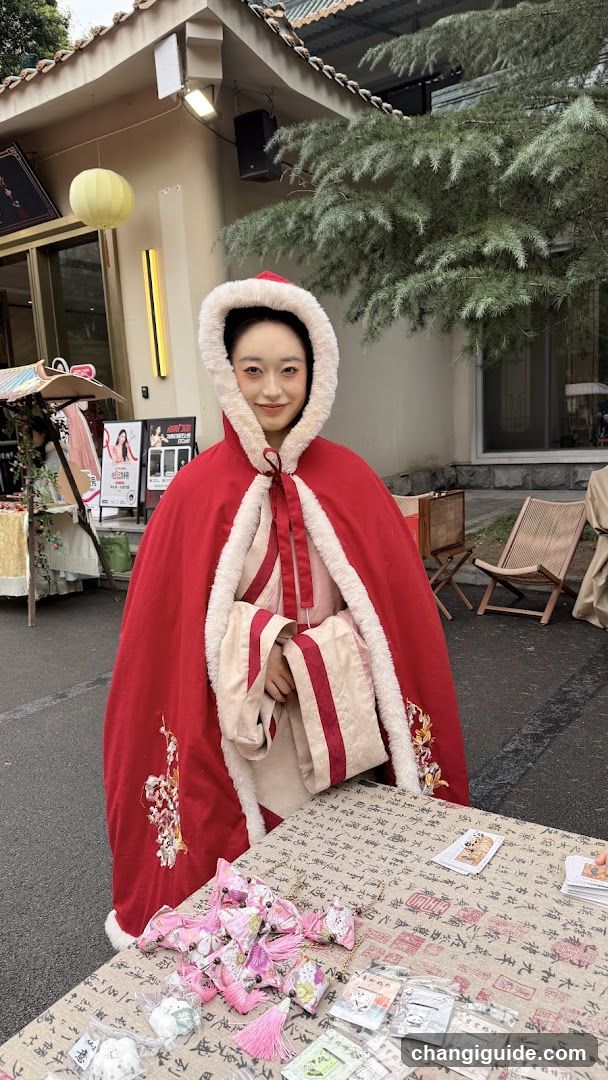 Red Cloak Model at Market Stall