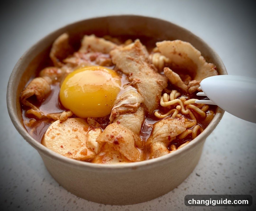 Bowl of spicy noodles with egg and meat