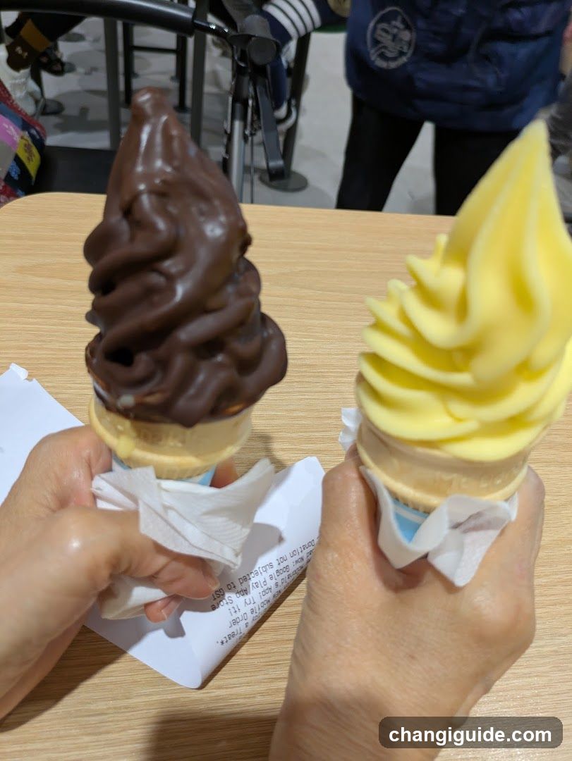 Two soft-serve ice cream cones held in hands