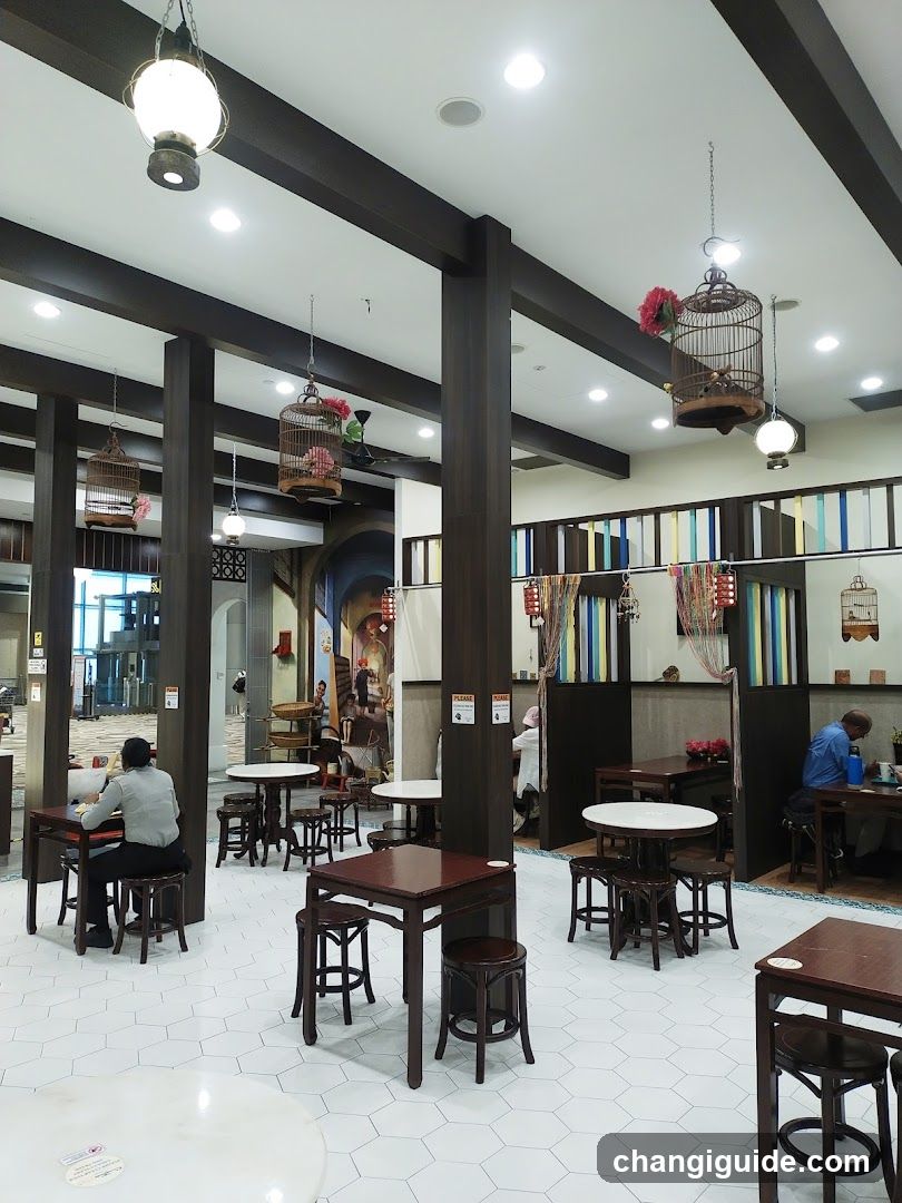 Interior of a restaurant with wooden furniture and hanging birdcages