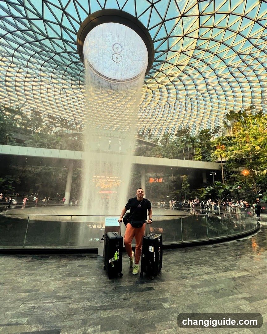 Traveler with luggage near indoor waterfall