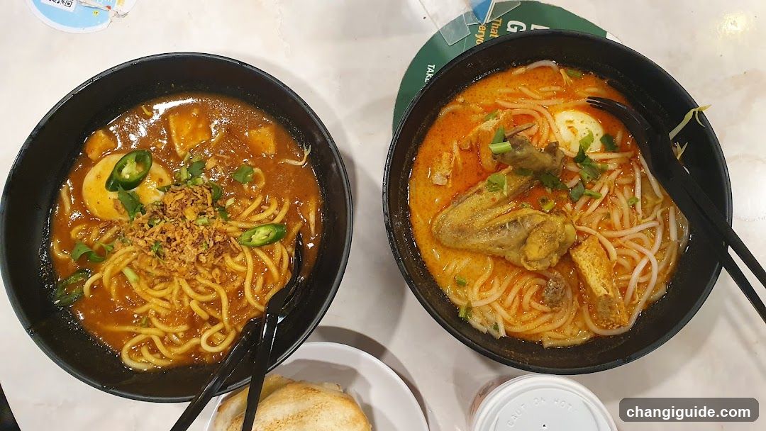 Two bowls of spicy noodles with chicken and egg