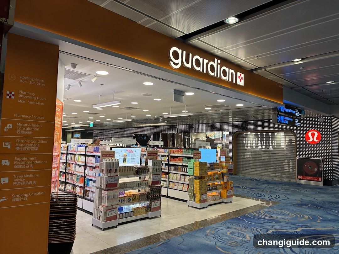 A well-lit pharmacy storefront with a prominent 'guardian' sign above the entrance. The store features shelves stocked with various products, including health and beauty items. A blue patterned carpet covers the floor outside the shop. Adjacent to the pharmacy is an L'Oreal store.