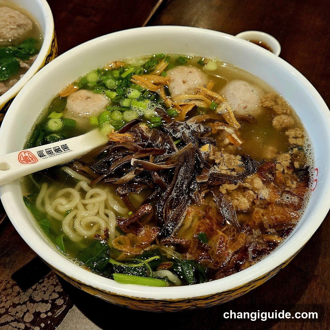 Bowl of Noodle Soup with Meatballs and Toppings