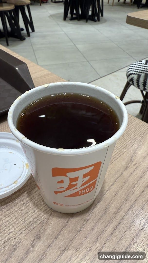 Cup of dark beverage on table