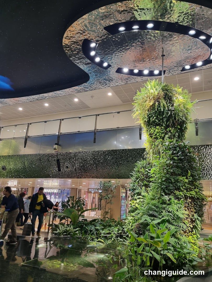 Jungle-themed indoor space with vertical garden and ceiling art