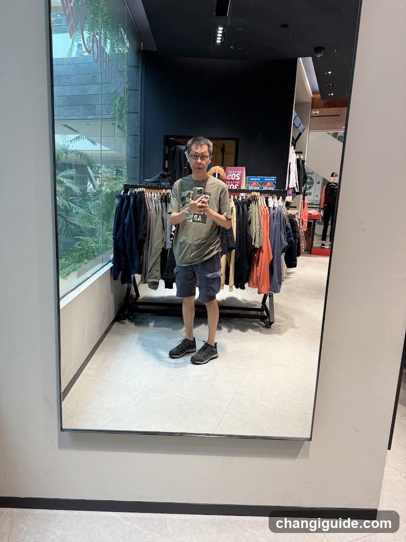 Man taking mirror selfie in clothing store