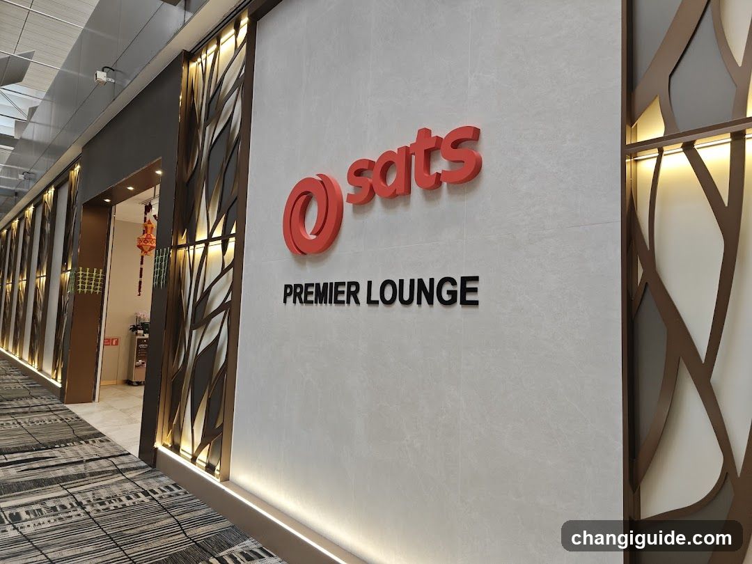 Photo of the physical storefront facade showing a wall-mounted sign with red 'sats' logo and black 'PREMIER LOUNGE' text. Decorative illuminated panels flank the entrance, leading into an interior space visible through glass doors.