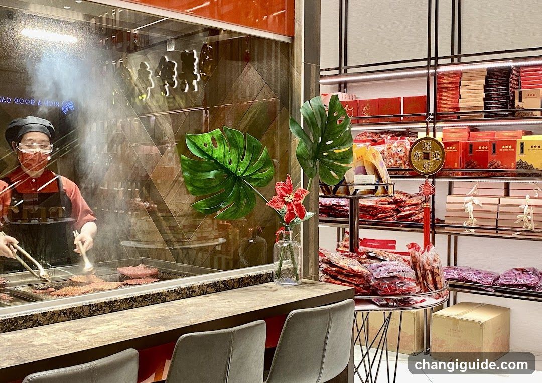 Food stall interior with staff cooking and packaged goods display