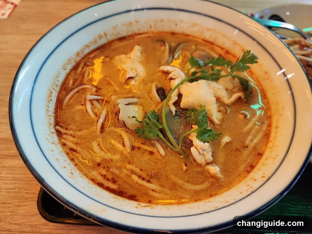 Bowl of Thai-style noodle soup with fish and herbs