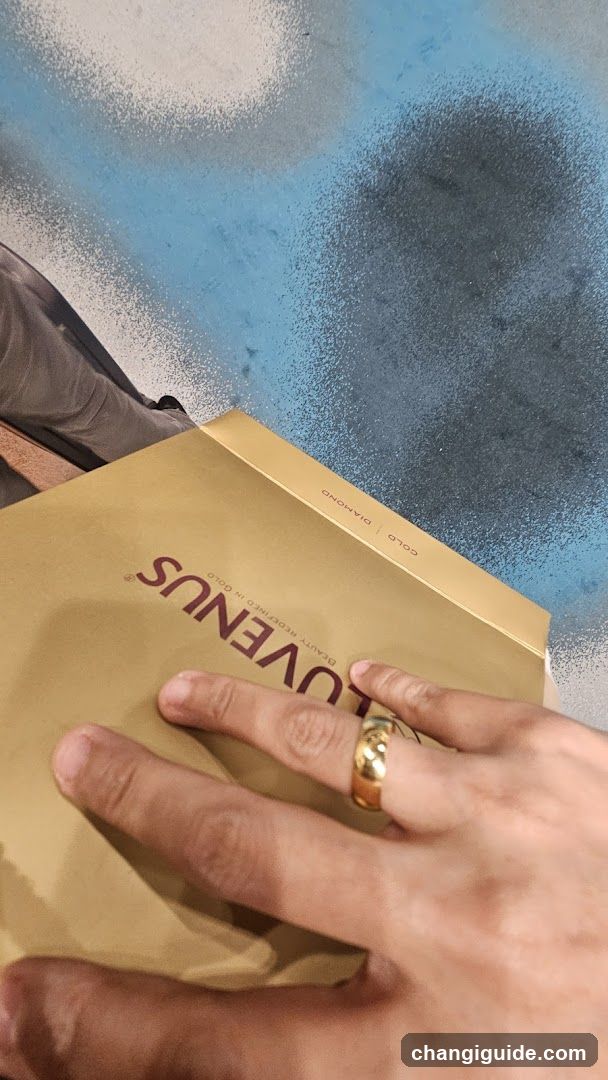 Hand holding a golden box with 'LOVENUS' branding