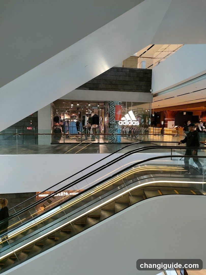 Shopping Mall Interior with Escalator and Storefronts