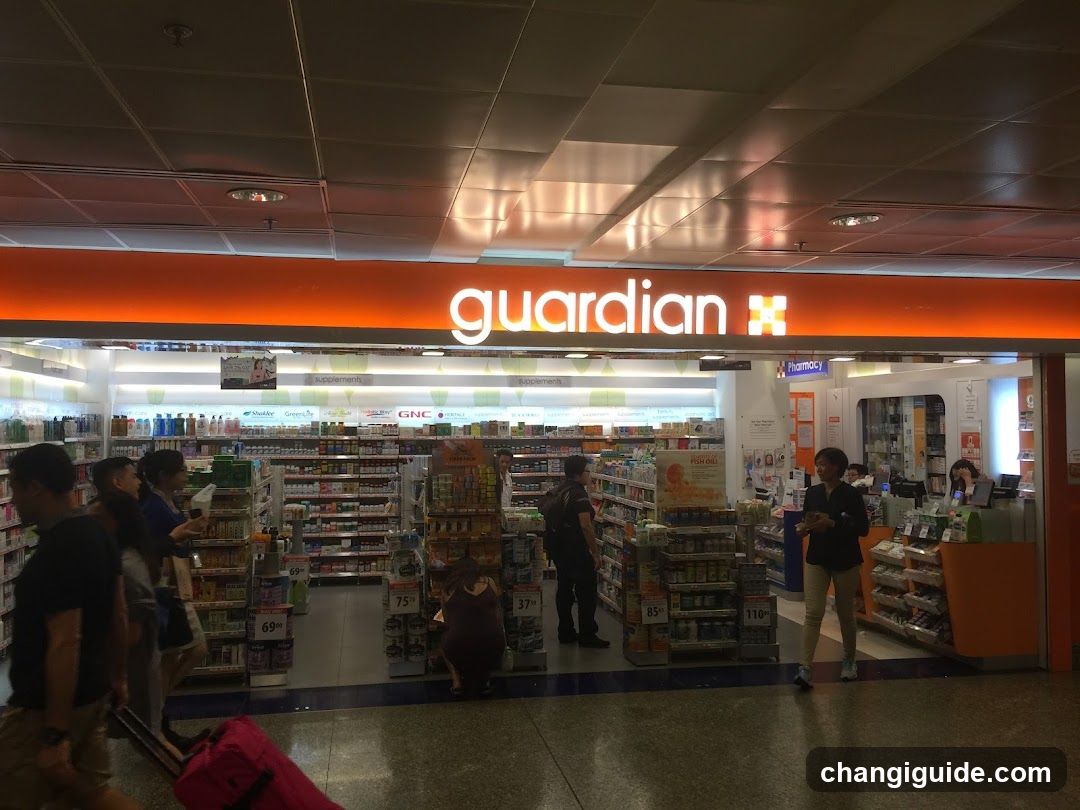 Interior view of a Guardian pharmacy with visible signage above the entrance. Shelves stocked with products, customers browsing, and staff at counter.