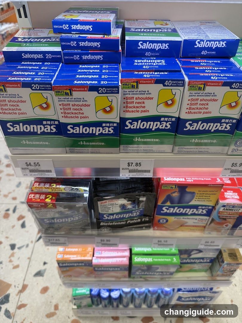 A close-up view of a pharmacy shelf stocked with Salonpas brand pain relief patches in various packaging sizes and colors, including blue, red, and green boxes. Price tags are visible below each product row.