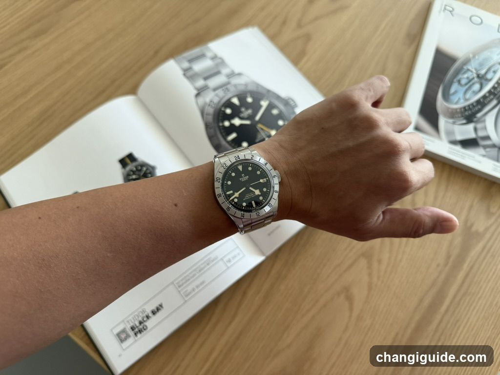 Watch on wrist with catalog pages in background