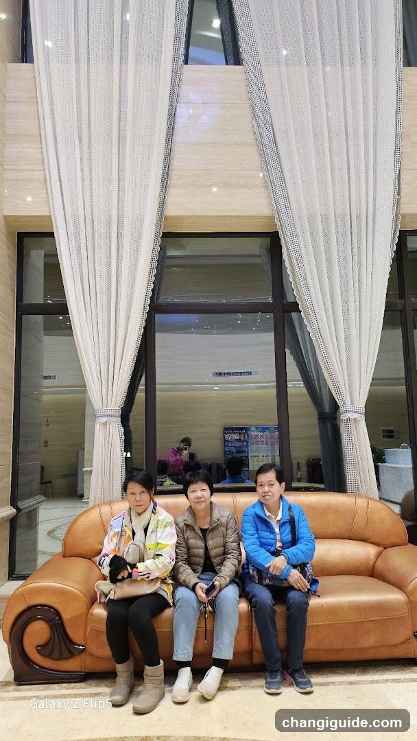 Three people sitting on a sofa in a lobby
