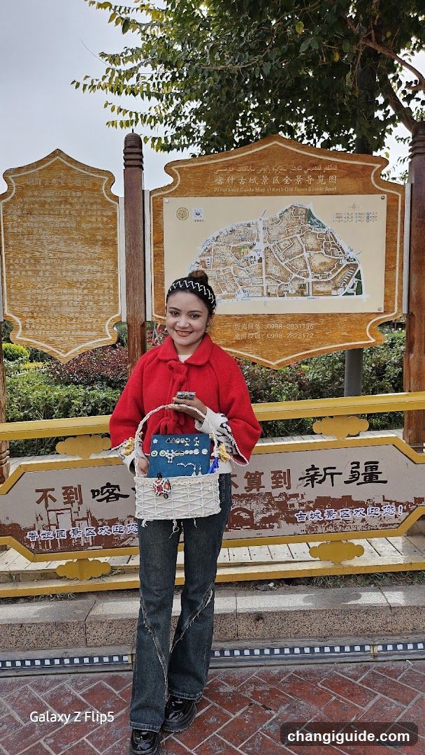 Woman in red coat standing before a signboard