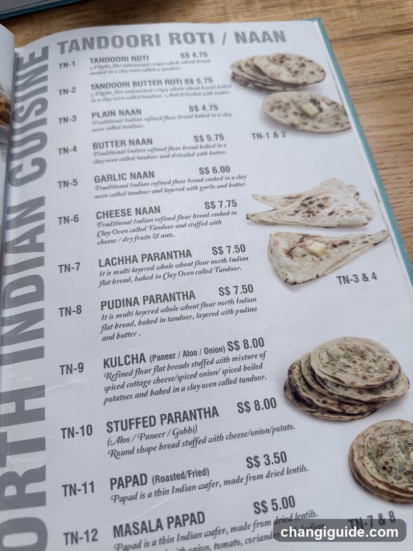 A printed menu page featuring North Indian dishes, including Tandoori Roti/Naan and related items like Butter Naan, Garlic Naan, Cheese Naan, Lachha Parantha, Pudina Parantha, Kulcha, Stuffed Parantha, Papad, and Masala Papad.