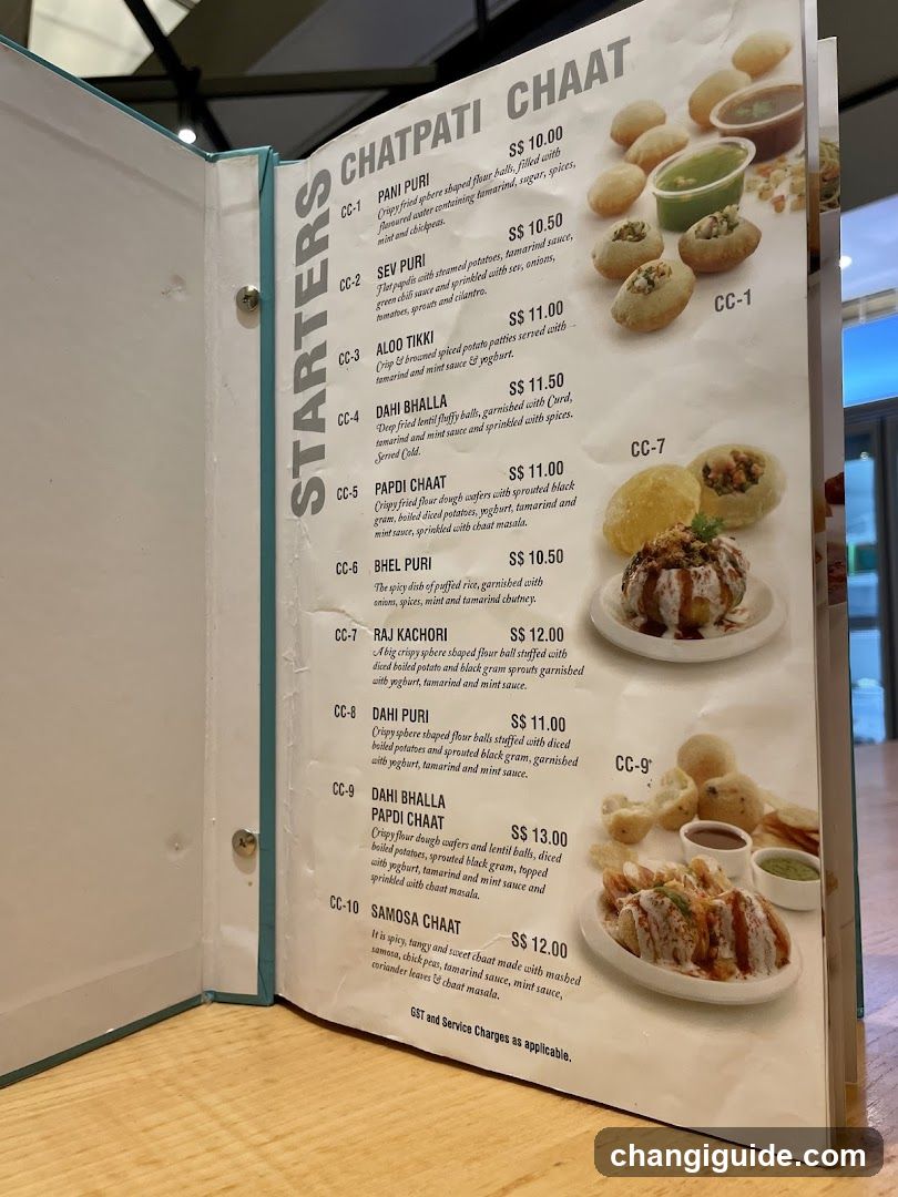 Open menu book displaying Indian street food items with prices and descriptions.