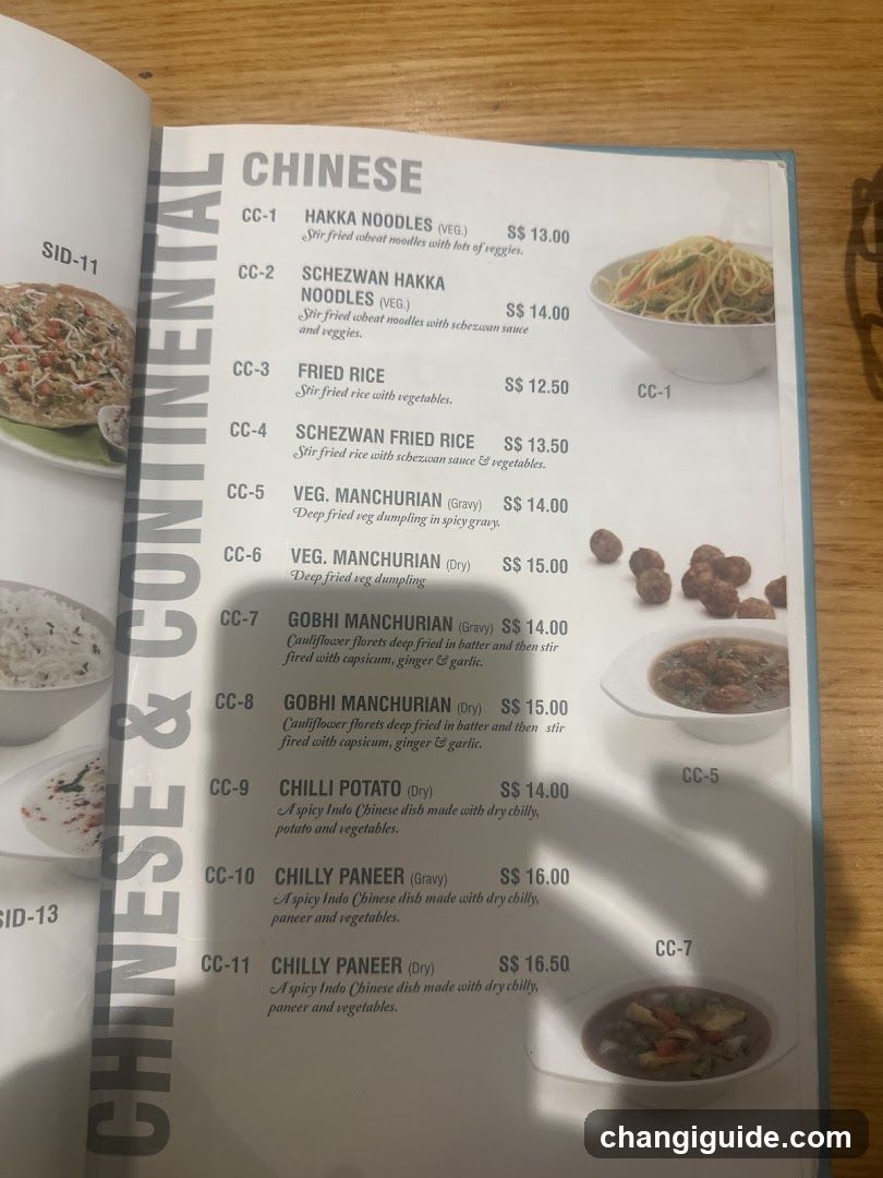 A printed menu page from a Chinese restaurant, showing items like Hakka Noodles, Schetzwan Noodles, Fried Rice, and various Manchurian dishes with prices ranging from $13.00 to $16.50.
