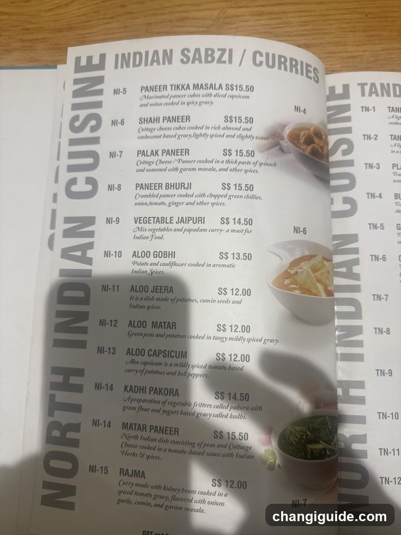 A printed menu page from a North Indian Cuisine restaurant, displaying various curry dishes with prices and brief descriptions.