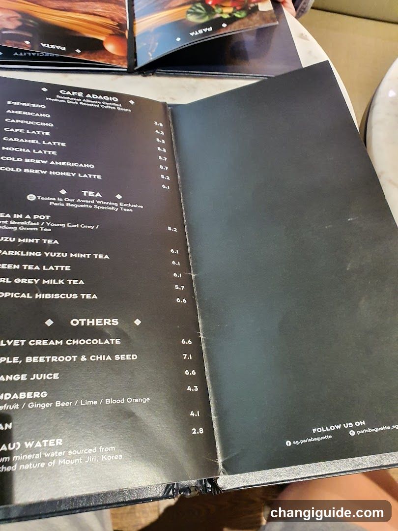 A close-up of an open menu from Café Abasio, featuring coffee and tea options with prices in KRW.