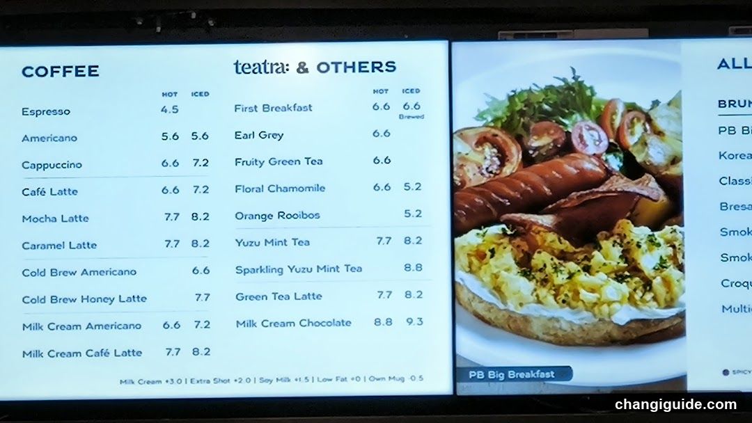 Digital menu display showing coffee and other beverage options with prices, including Espresso, Americano, Cappuccino, Café Latte, Mocha Latte, Caramel Latte, Cold Brew varieties, Milk Cream drinks, tea selections like Earl Grey, Yuzu Mint Tea, and breakfast items such as First Breakfast and PB Big Breakfast.