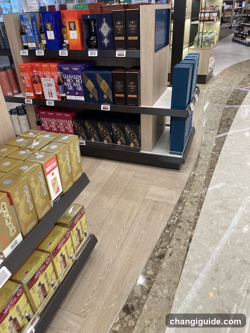 Interior view of a liquor store with shelves displaying various alcohol products including Glenfiddich, Johnnie Walker, and other brands. The floor is tiled with light wood and marble accents.