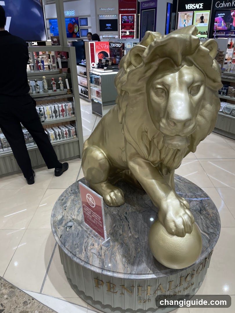 A golden lion statue sits on a marble pedestal with 'PENHALIGON' inscribed at the base, located inside a perfume shop. Shelves display various bottles and products in the background.