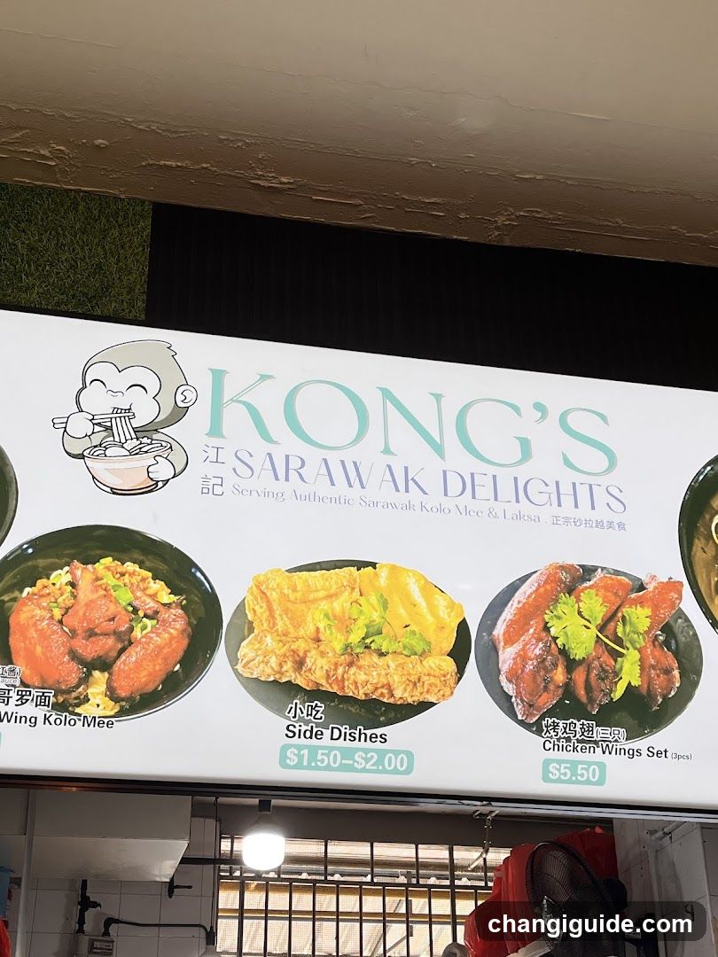 A shop front featuring a large signboard with the name 'KONG'S SARAWAK DELIGHTS' and an illustration of a monkey eating noodles. The sign displays images of three dishes: Wing Kolo-Mee, Side Dishes (priced between $1.50-$2.00), and Chicken Wings Set ($5.50). Below the sign, part of the storefront is visible, including a window with bars and some equipment like a fan.