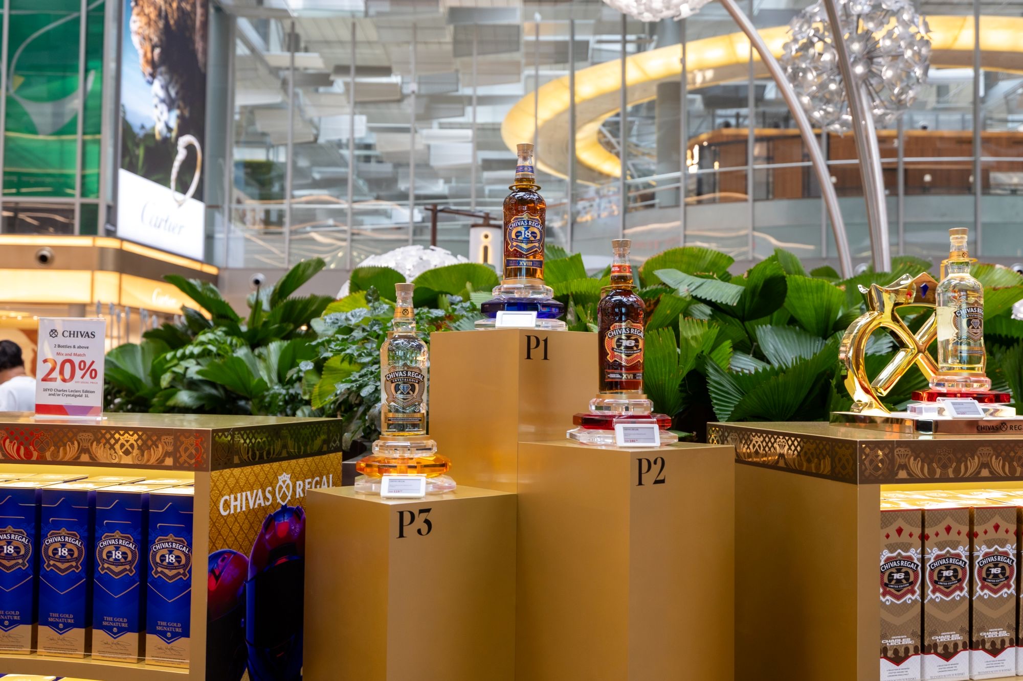 Chivas Regal bottles on P1, P2 and P3 podiums in the Terminal 3 Lotte Duty Free pop-up, with a 20 percent sign
